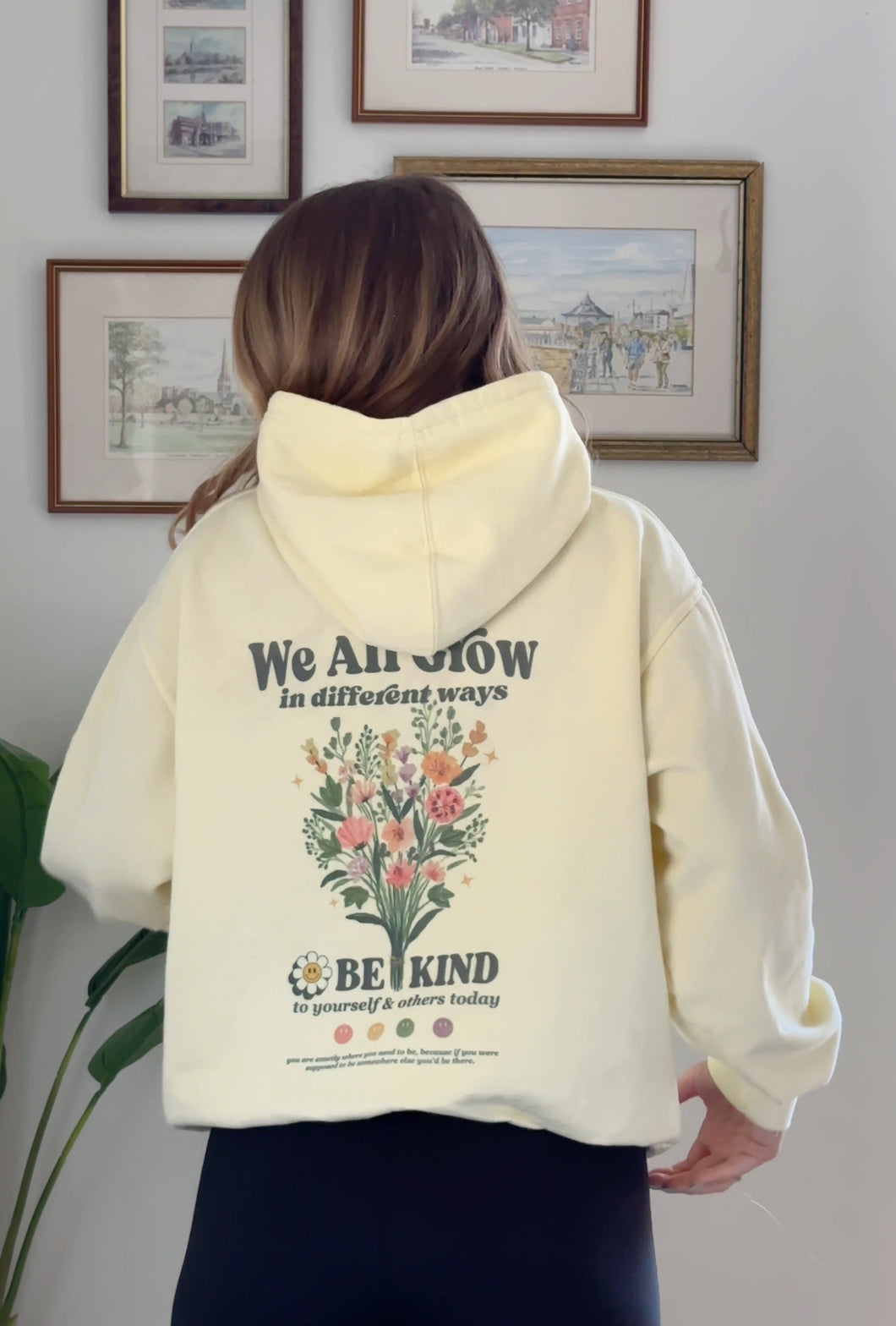 Light yellow Be Kind hooded sweatshirt with a floral design that includes embroidery and screenprinting elements