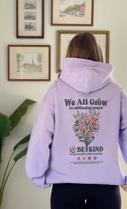 Lavendar Be Kind hooded sweatshirt with a floral design that includes embroidery and screenprinting elements