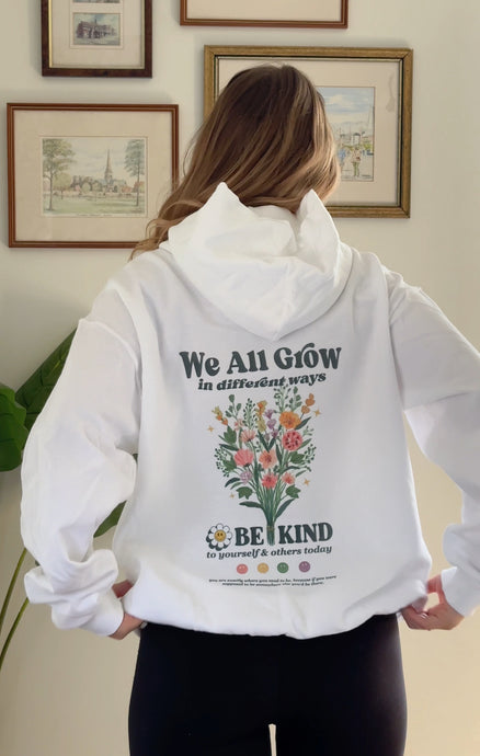 cream colored Be Kind hooded sweatshirt with a floral design that includes embroidery and screenprinting elements