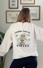 Load image into Gallery viewer, Cream sweatshirt with Drink Local Coffee screenprinted on the back of the sweatshirt with a fun coffee cup logo
