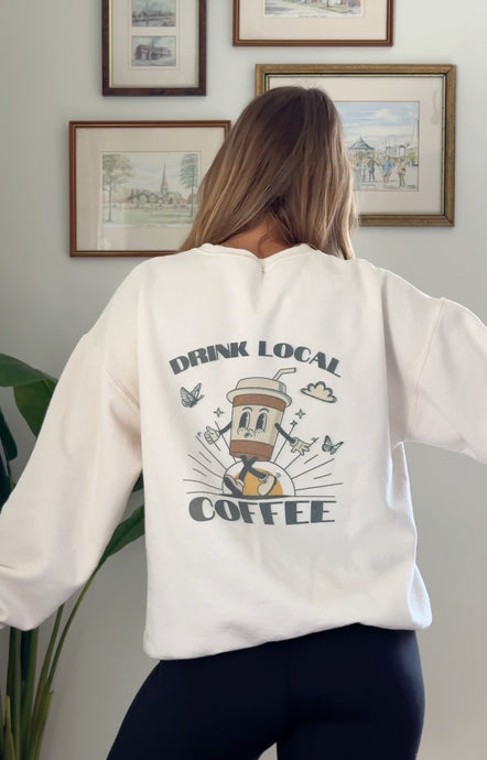 Cream sweatshirt with Drink Local Coffee screenprinted on the back of the sweatshirt with a fun coffee cup logo