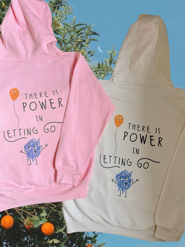 there is power in letting go hoodie in pink and cream colorways. orange tree in the background