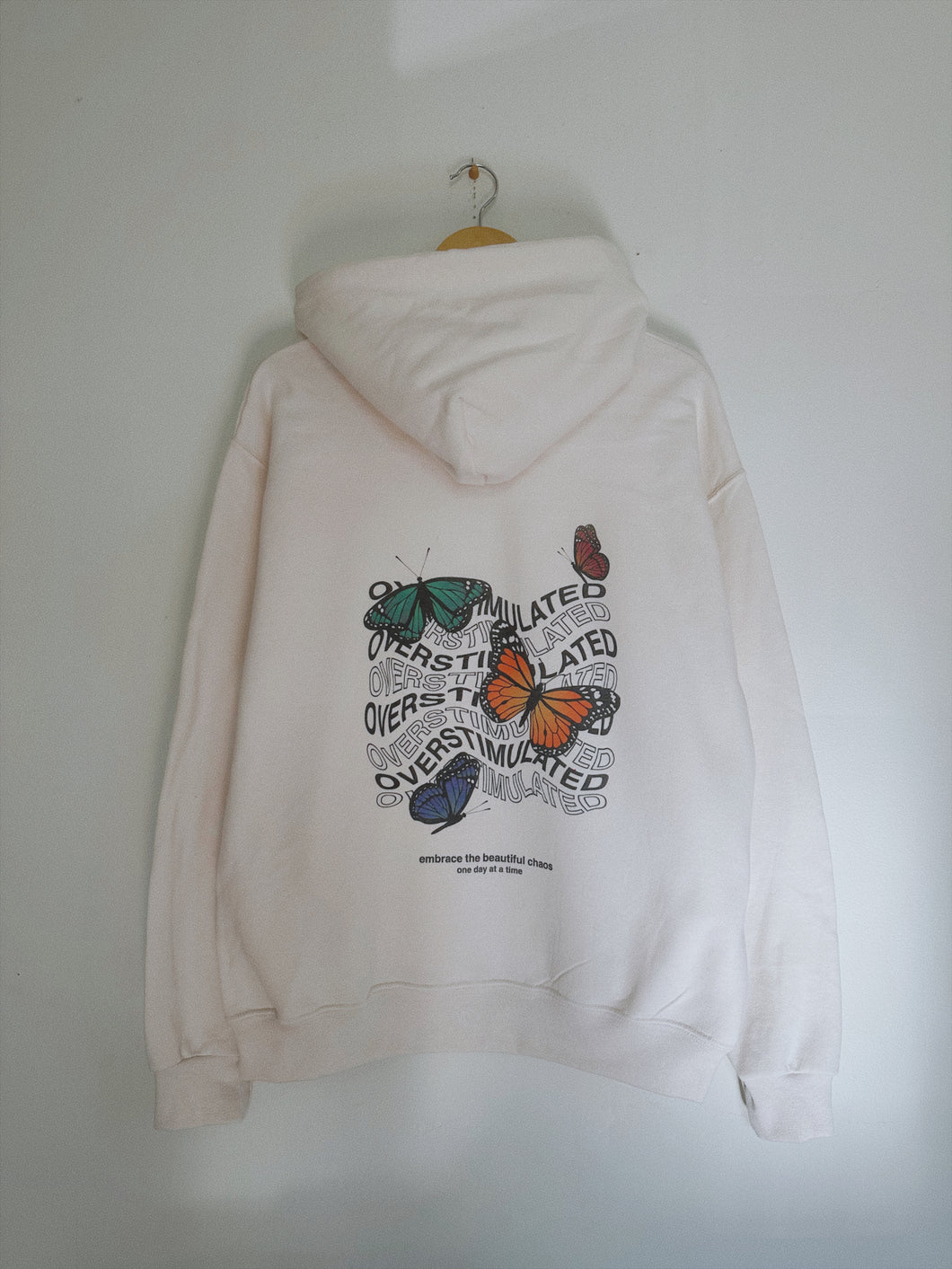 overstimulated hoodie with a large butterfly design on the back of the sweatshirt