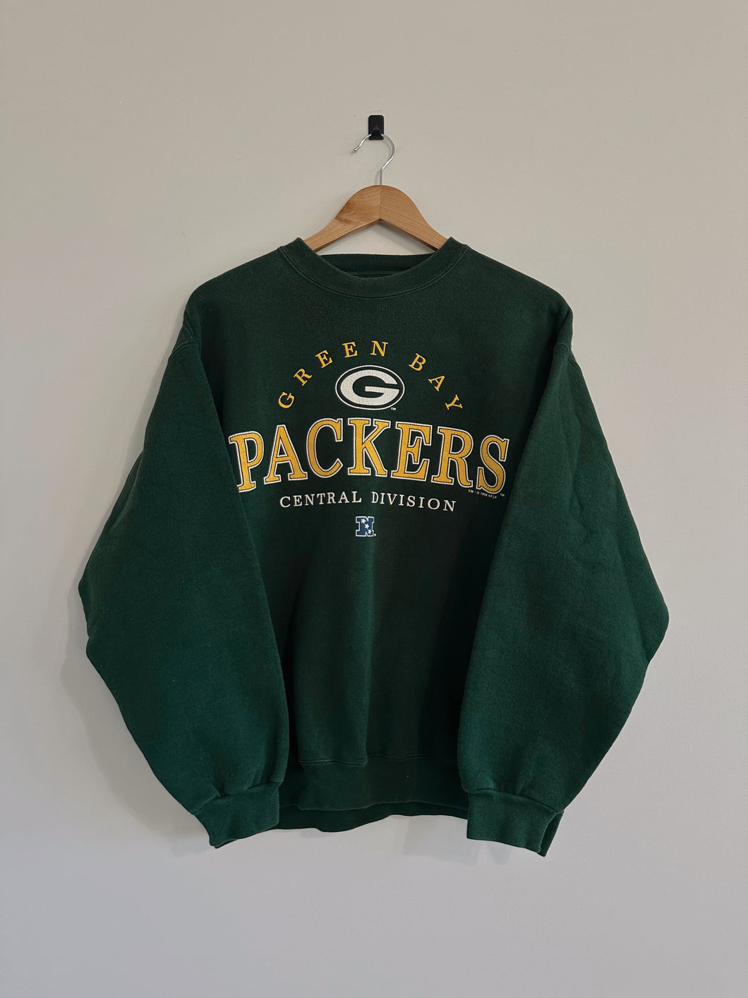 Green Bay Packers sweatshirt on a hanger against a plain background