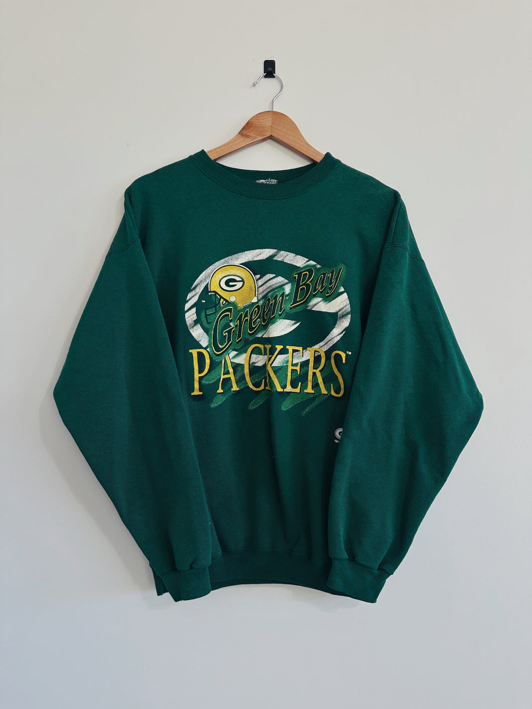 Green Bay Packers sweatshirt on a hanger against a white background